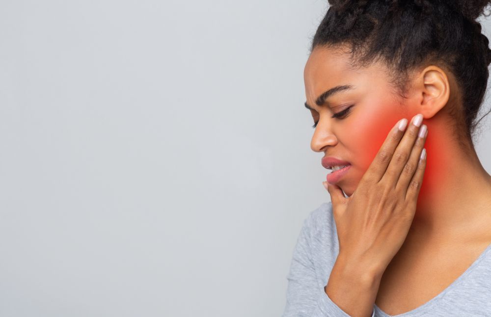 Patient holding her jaw with toothache